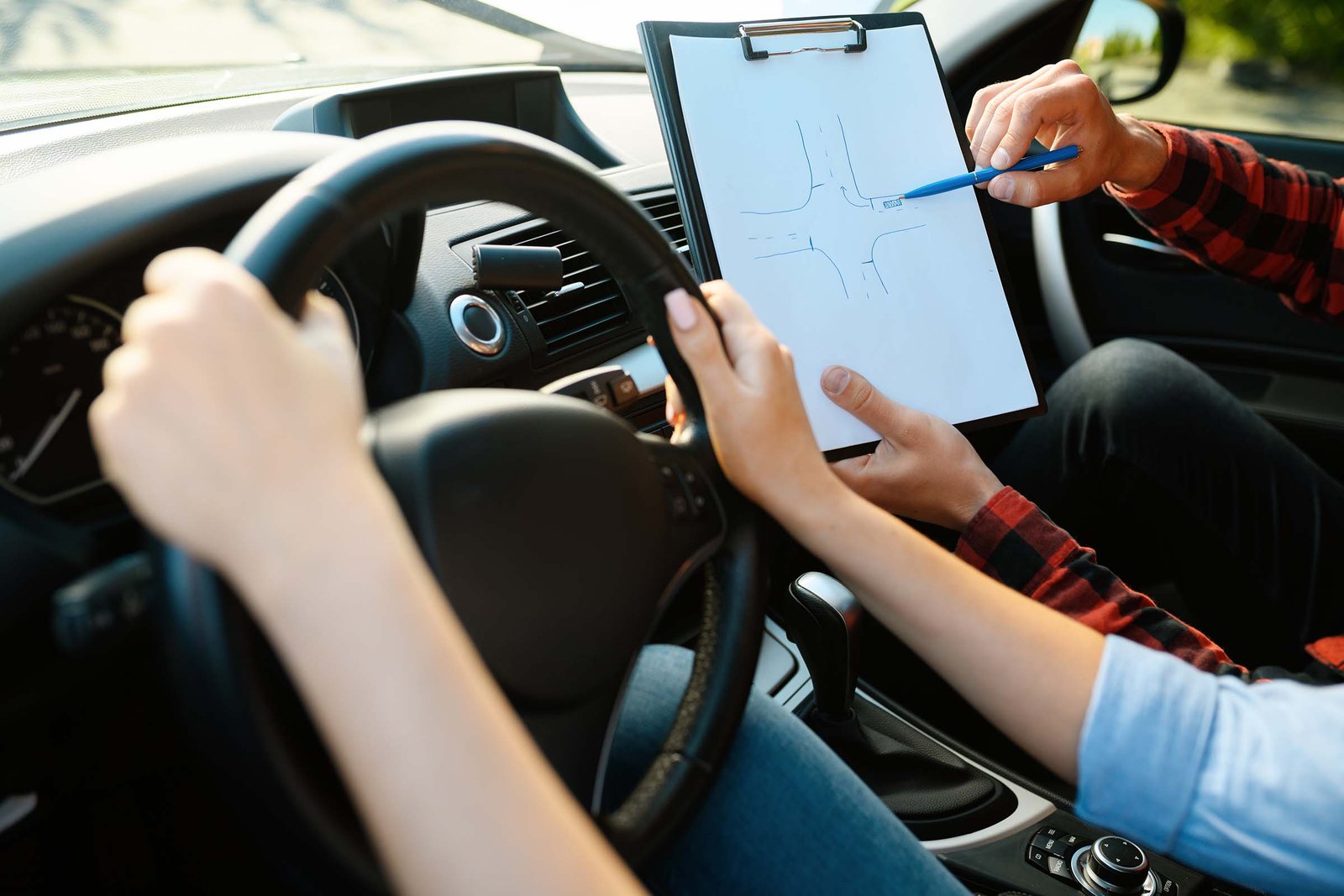 Driving instructor reviewing a checklist with a learner driver