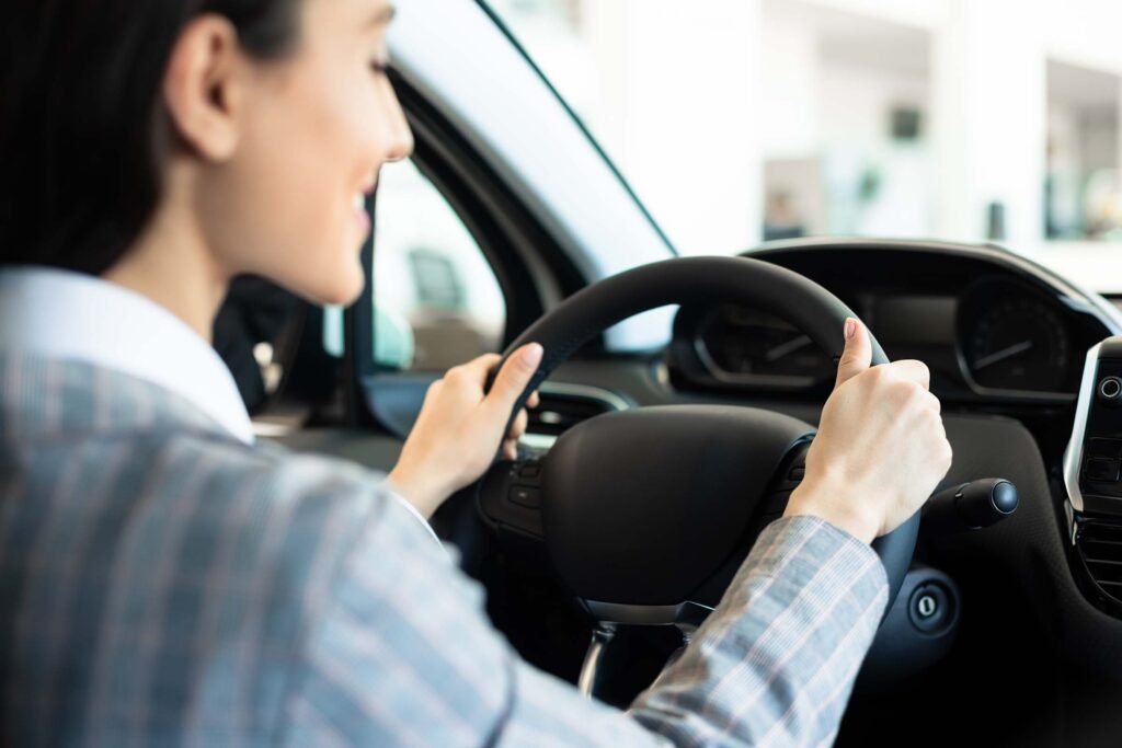 Young woman driving her car after passing her driving test